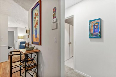 Hall with a textured ceiling and baseboards