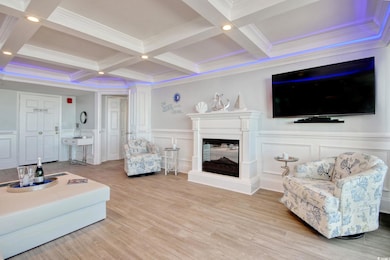 Living room with beam ceiling, light hardwood / wood-style flooring, and a multi sided fireplace