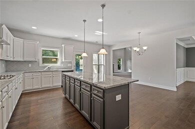 Kitchen with dark wood-type flooring, white cabine