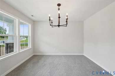Spare room featuring carpet flooring and a chandelier