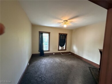 Carpeted spare room with baseboards and ceiling fan