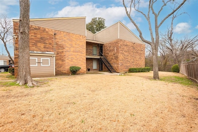 Rear view of property with stairs, brick siding, a