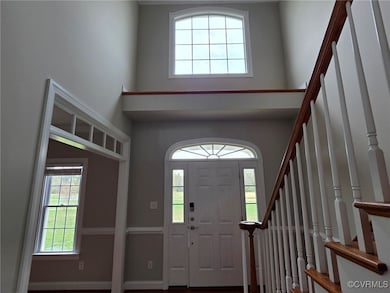 Foyer with stairs and a towering ceiling