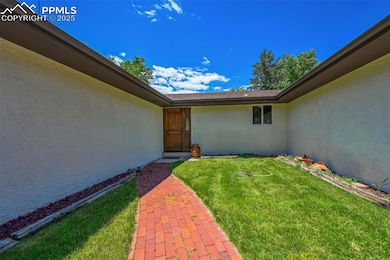 Entrance to property with stucco siding and a yard