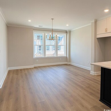 Unfurnished dining area with crown molding, light wood finished floors, a chandelier, and recessed lighting