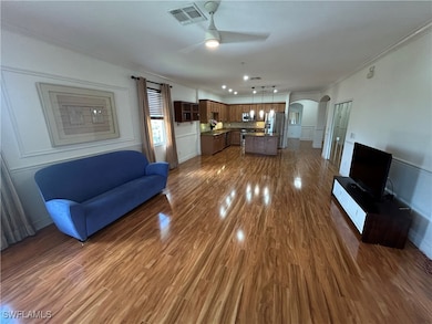 Living room with crown molding, arched walkways, c