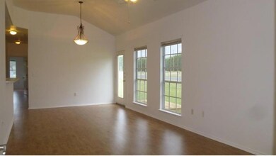 Unfurnished room featuring lofted ceiling, a ceil