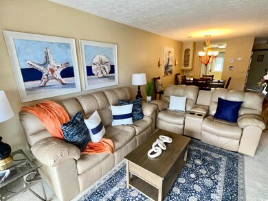 Living area featuring a notable chandelier and a t