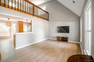 Unfurnished living room with high vaulted ceiling