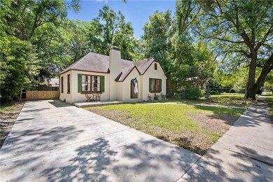 Tudor house with a chimney, fence, a front lawn, c