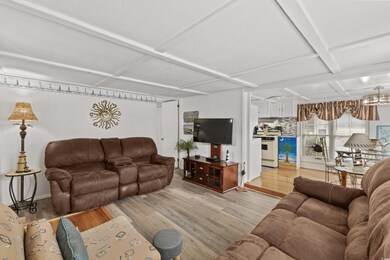 Living room with coffered ceiling and light wood finished floors