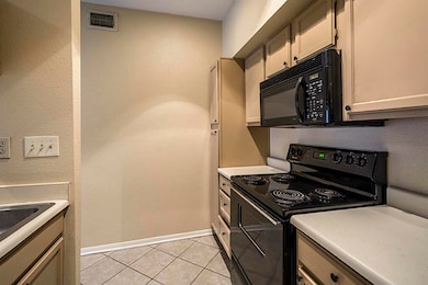 Kitchen has black appliances with built in microwa