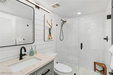 Bathroom with vanity, walk in shower, and toilet
