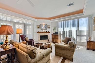Living area featuring visible vents, ceiling fan,