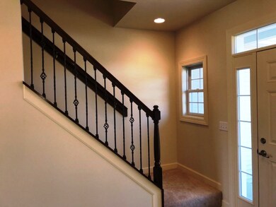 Foyer with wood and wrought iron staircase balustr