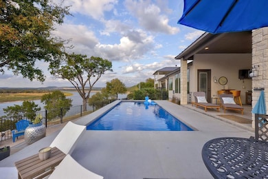 View of pool with a fenced in pool, a water view,