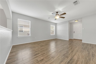 Empty room with visible vents, baseboards, wood fi