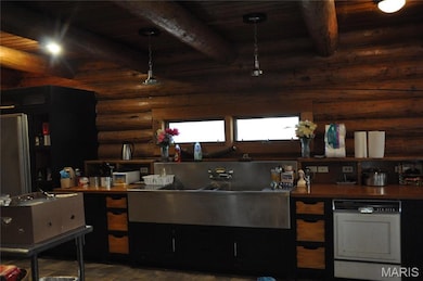 Kitchen featuring a wood ceiling with exposed beams and dark cabinetry