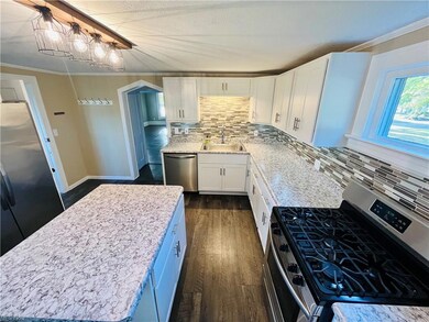 Kitchen with a center island, sink, backsplash, wh