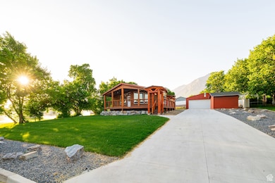 View of front of home with an outdoor structure, a front lawn, a deck with mountain view, and a detached garage