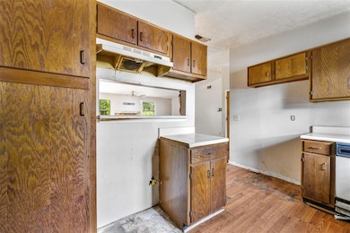 Kitchen featuring under cabinet range hood, brown 