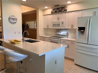 Kitchen with light stone countertops, white applia