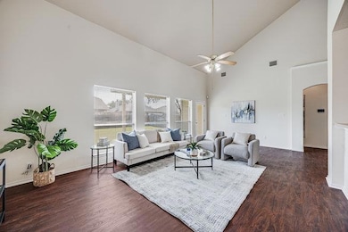 Living area with arched walkways, ceiling fan, hi