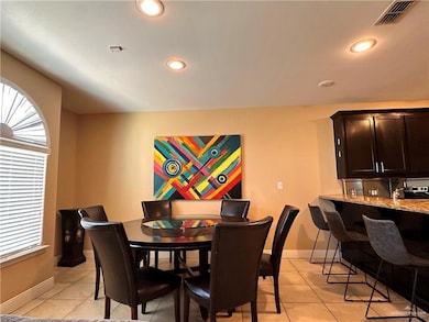 Dining area with light tile patterned flooring and recessed lighting