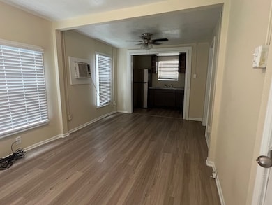 Unfurnished living room featuring dark wood finished floors, ceiling fan, and a wall mounted air conditioner