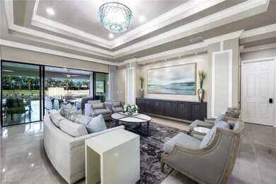 Great room featuring a raised ceiling, crown molding, chandelier, bulit-in