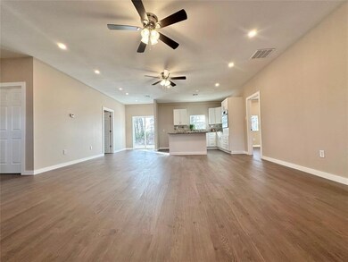 Unfurnished living room featuring ceiling fan and 