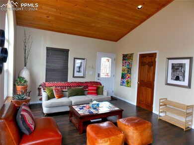 Living room featuring wooden ceiling, high vaulted