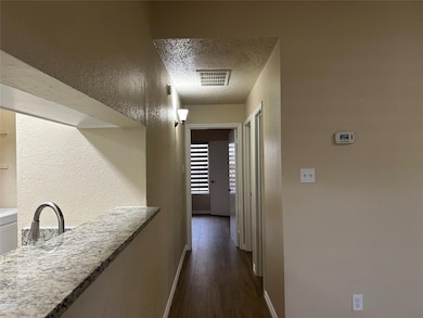 Hall with baseboards, dark wood-style floors, a te