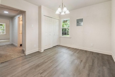 Unfurnished dining area with electric panel, healthy amount of natural light, and wood finished floors