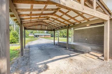 View of parking / parking lot featuring a carport and dirt driveway