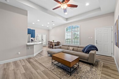 Living room featuring ceiling fan, light wood-typ