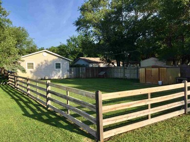 Side yard with split rail fence lined with wire fe
