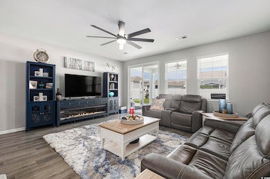 Living room featuring ceiling fan and wood finished floors