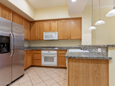Kitchen featuring white appliances, a sink, a peni