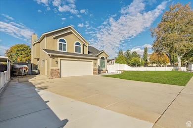 View of front of house with driveway, stone siding, an attached garage, a chimney, and stucco siding