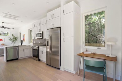 Kitchen with tasteful backsplash, white cabinets,