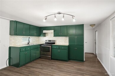 Newly remodeled Kitchen with electric stove, subway tile backsplash and freshly painted cabinets.