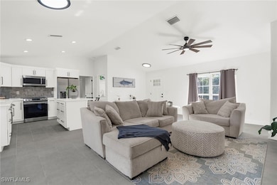 Living room with ceiling fan and lofted ceiling