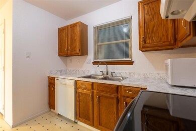 Kitchen featuring white appliances, a sink, light