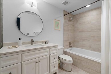 Bathroom featuring tiled shower / bath, vanity, and tile patterned floors