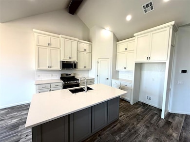 Kitchen with tasteful backsplash, gray cabinets, white cabinetry, appliances with stainless steel finishes, and recessed lighting