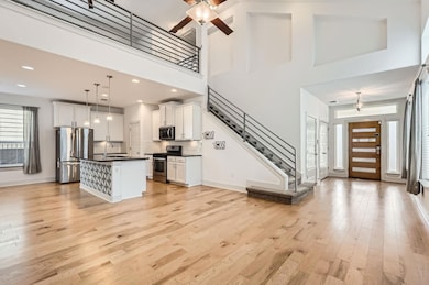 Kitchen featuring white cabinets, a high ceiling,