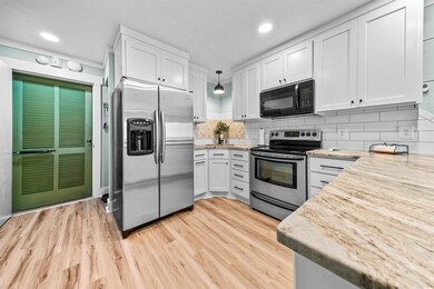 Kitchen with white cabinetry, hanging light fixtur