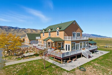 South west corner of home featuring french doors, stucco siding, a deck with mountain view, a yard, and stairs.