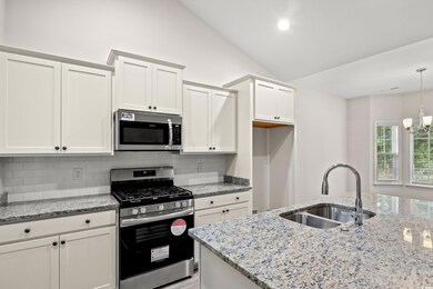 Kitchen with vaulted ceiling, appliances with stai